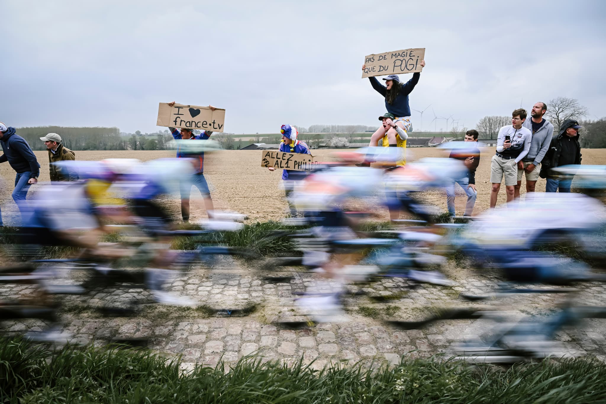 Paris Roubaix peloton on the cobbles, fans cheering