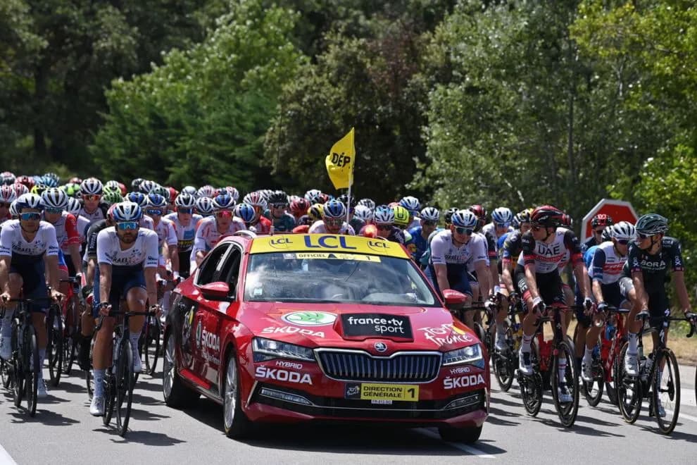Tour de France peloton led by race director car, Israel-Premier Tech, UAE, Bora riders visible