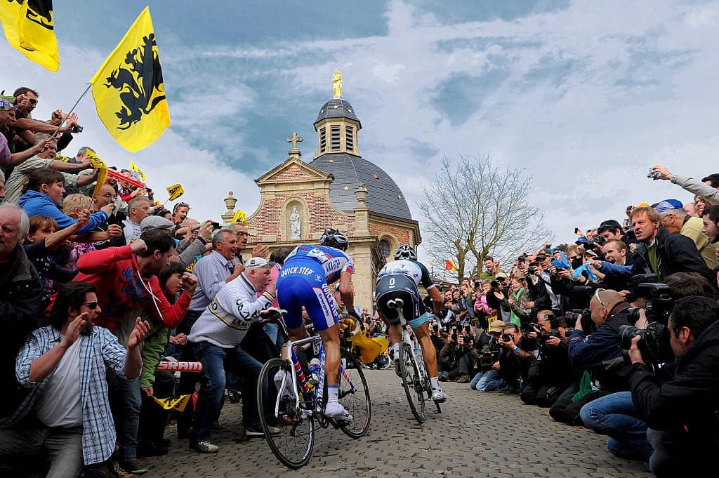 Cyclists on cobbles, Flanders flags, Soudal Quick-Step rider