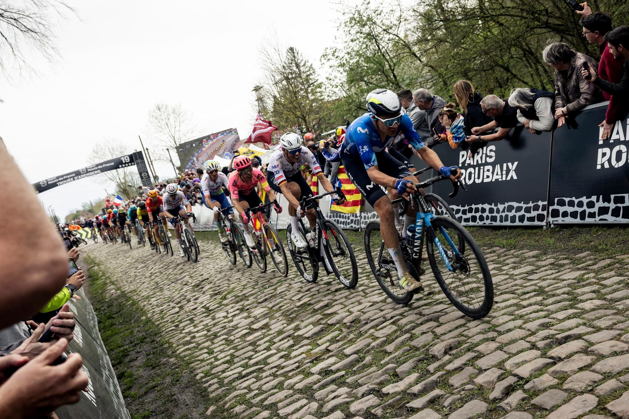 Paris-Roubaix peloton on cobbles, Movistar rider in front