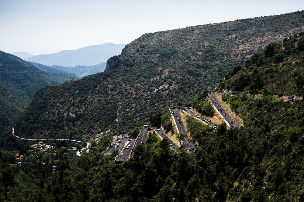 Tour de France peloton climbs a winding mountain road